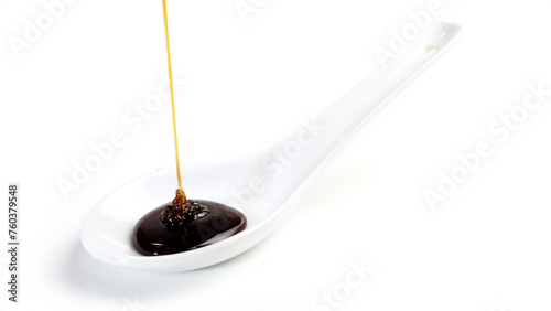Liquid sunflower lecithin pouring on a spoon isolated on white Background photo