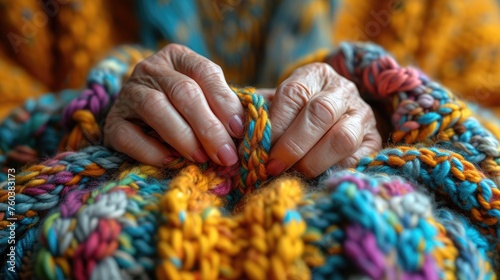 The delicate hands of an elder person knit with multicolored wool, showcasing the timeless craft of knitting and its intricate beauty.