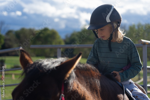 Children learning to ride horses