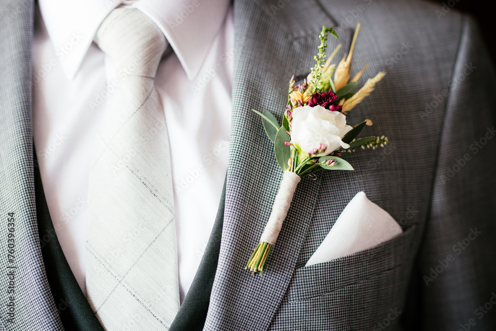 Elegant Groom with Boutonniere Rose Flower on Suit During Wedding Preparation and Grey Tie Close-up