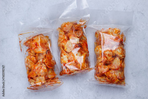 Keripik Singkong Balado or Balado Cassava Chips is a kind of Indonesian cracker made from cassava put in a clear plastic bag photo