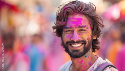Portrait of happy young man covered with pink paint at Holi festival