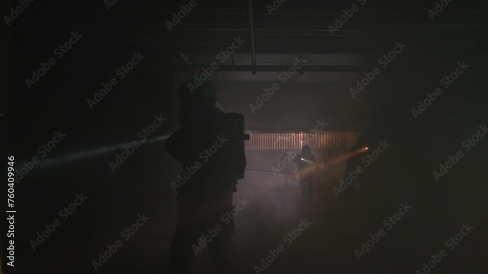 Firefighter Shines His Flashlight Into A Dark House