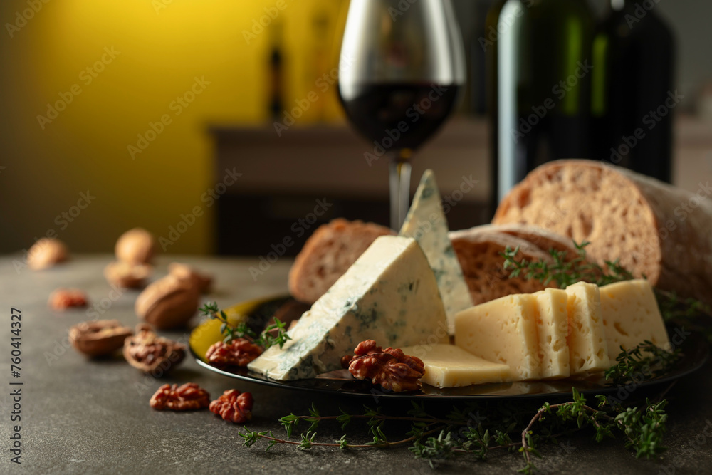 Cheese, bread, red wine, and walnuts on a kitchen table. Cheese, bread, red wine, and walnuts on a kitchen table.