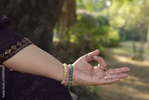 Mid aged woman doing yoga in lush green park. yoga poses. meditating woman. spirituality and fitness. Variety of Indian poses. International Yoga Day. Closeup of hands. 