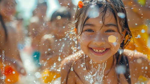 A delighted cute kid partakes in the lively street festivities of Thailand's Songkran Festival, engaging in a playful water fight with a water gun.