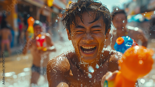 A delighted young man partakes in the lively street festivities of Thailand's Songkran Festival, engaging in a playful water fight with a water gun.