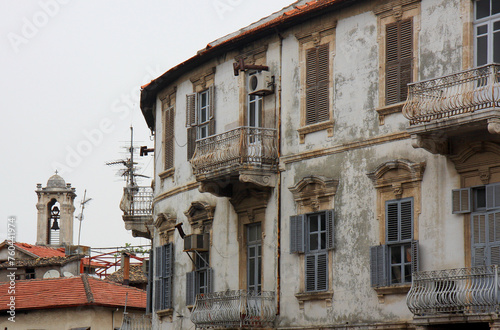 Bell Tower of The Greek Orthodox Church with Cross and Abandoned Greek Home with Shutters and Balconies in Hatay, Turkey