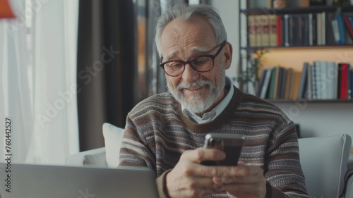 Joyful senior man with glasses discovering the digital world on his smartphone.