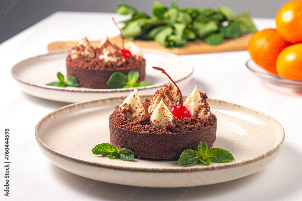 Delicious chocolate tart garnish with cherry and mint. Classic dessert. Delicious chocolate tart garnish with cherry and mint. Classic dessert.