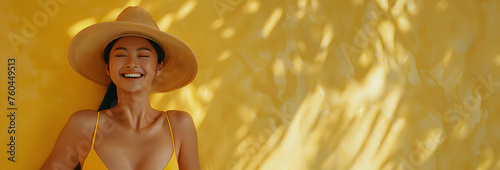 A joyful woman in a strapless top and straw hat smiles warmly, with sunlit golden palm shadows cast in the background.
 photo