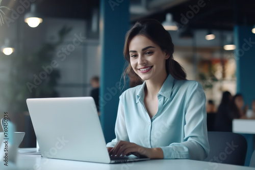 A woman is sitting at a table with a laptop in front of her