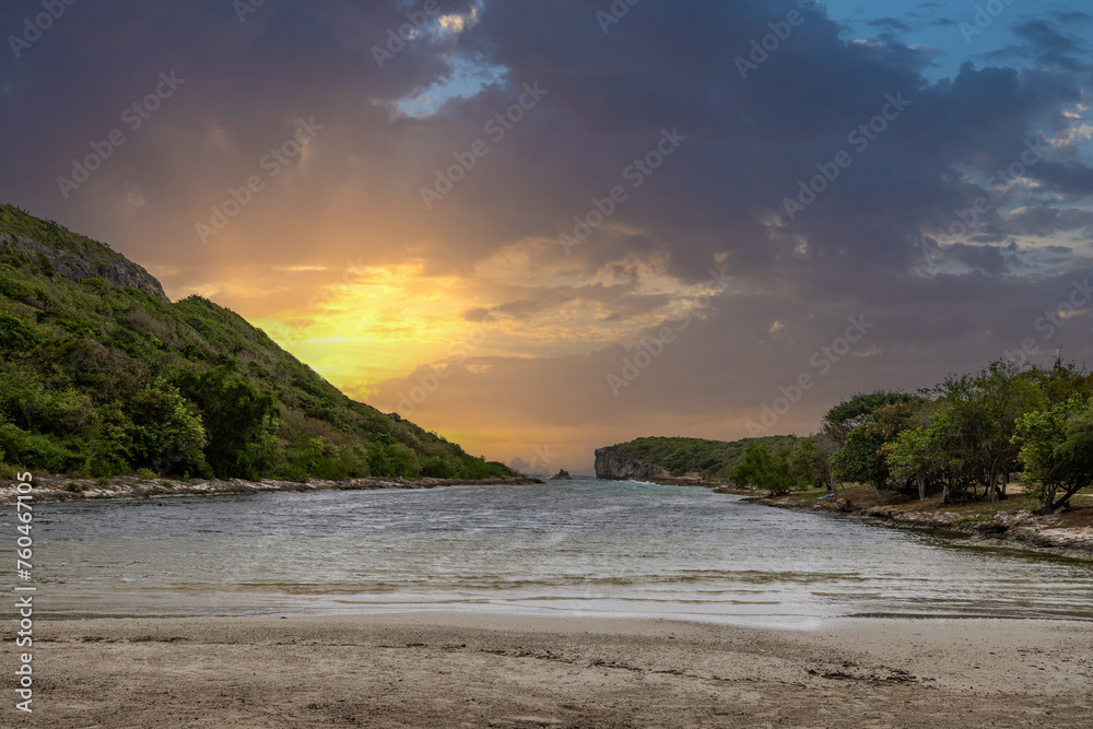 Rocky coast, long bay by the sea at sunset. Dangerous view of the Caribbean Sea. Tropical climate at sunset at La Porte d'Enfer, Grande Terre, Guadeloupe, French Antilles
