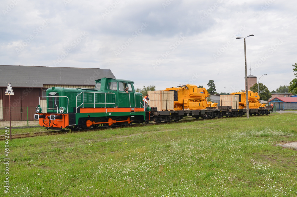 Huge crawler dozers transported by rail. Crawler dozers secured for rail transport. A train with wagons on a railway siding. Huge crawler dozers transported by rail. Crawler dozers secured for rail transport. A train with wagons on a railway siding.