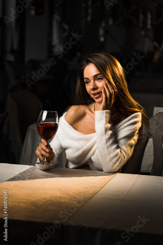 Young woman holding a glass of wine.Woman drinking wine in a restaurant.Red wine concept