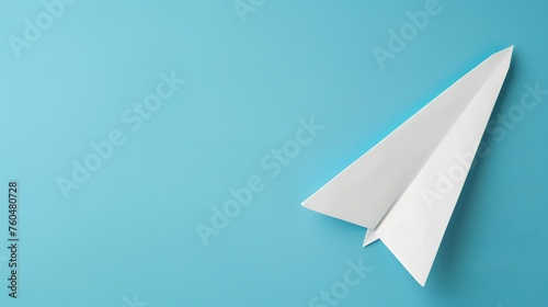 Flat lay of white paper plane and blank paper on pastel blue color background.Horizontal