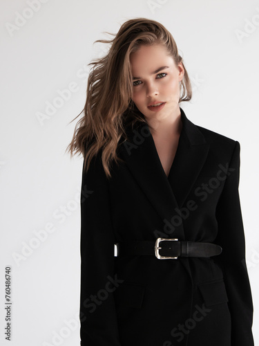 Beauty model woman in Leather pants . Model test portrait with young beautiful fashion model posing on grey background. Blond woman in a black blazer . Natural makeup