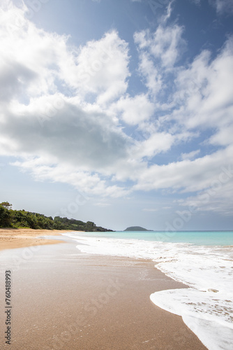 Lonely, wide sandy beach with a turquoise sea. Tropical plants of a bay in sunshine in the Caribbean. Plage de Cluny, Basse Terre, Guadeloupe, French Antilles, © Jan