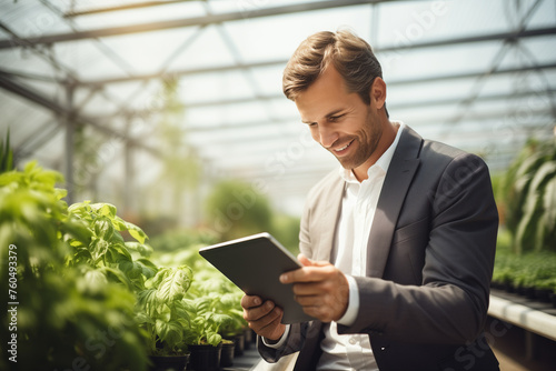a man working with tablet in the greenhouse smart farming digital agriculturist concept bokeh style background