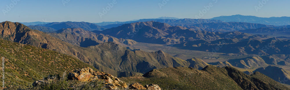 A mountain range with a clear blue sky in the background