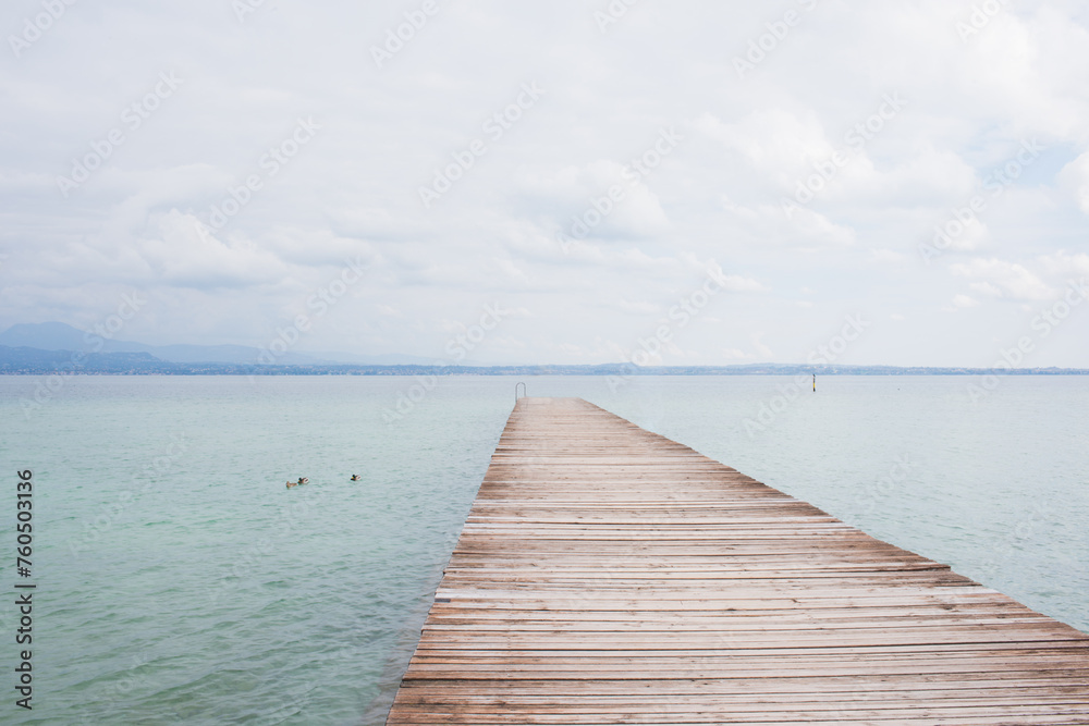 Old wooden pier over Garda lake, no people