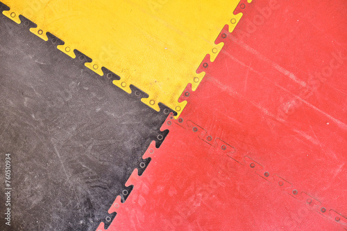 A yellow and red floor warning parking line on a textured floor inside a car park or industrial factory floor. dusty smooth and vibrant hazard warning.