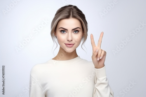 Beautiful woman gesture victory sign on plain background