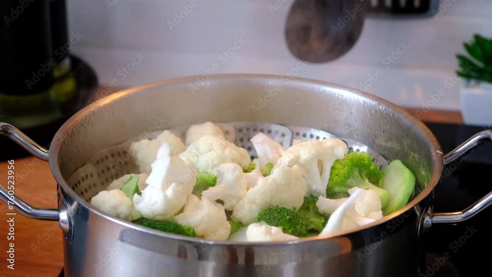 Broccoli and cauliflower are steamed in a saucepan - healthy diet, baby food, cooking in a steamer Broccoli and cauliflower are steamed in a saucepan - healthy diet, baby food, cooking in a steamer