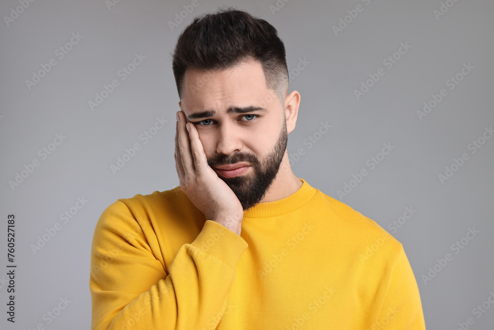 Portrait of sad man on light grey background