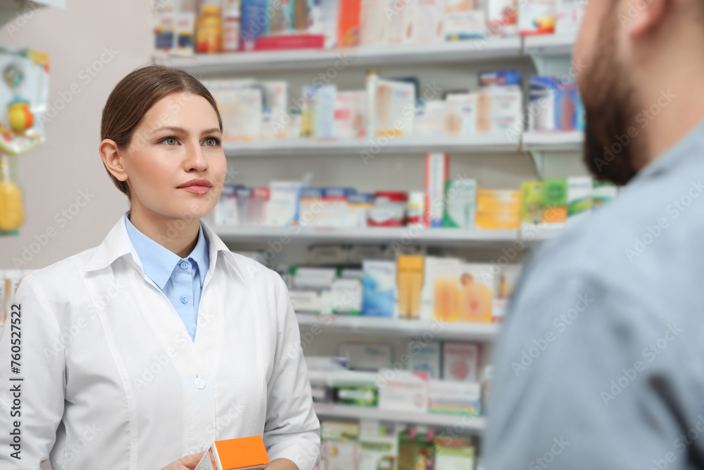 Professional pharmacist working with customer in modern drugstore