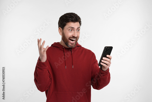 Emotional man with smartphone on white background