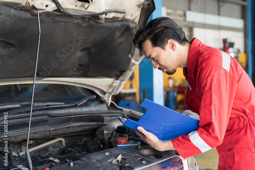 Male mechanic working at garage. Professional Asian male mechanics checks, repair and maintenance under hood of at auto car repair service. Car service and Maintenance concept