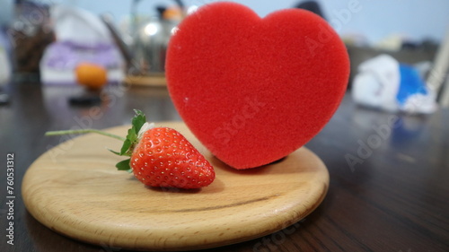 Fotografie wooden board with red heart and strawberry design for love and romantic concept