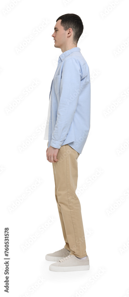 Young man in light blue shirt and beige pants on white background