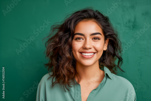 Portrait of happy young woman in front of the green concrete wall © Emre Akkoyun