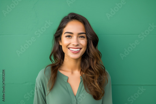 Portrait of happy young woman in front of the green concrete wall