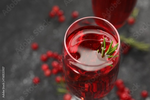 Tasty cranberry cocktail with rosemary in glass on gray table, closeup. Space for text