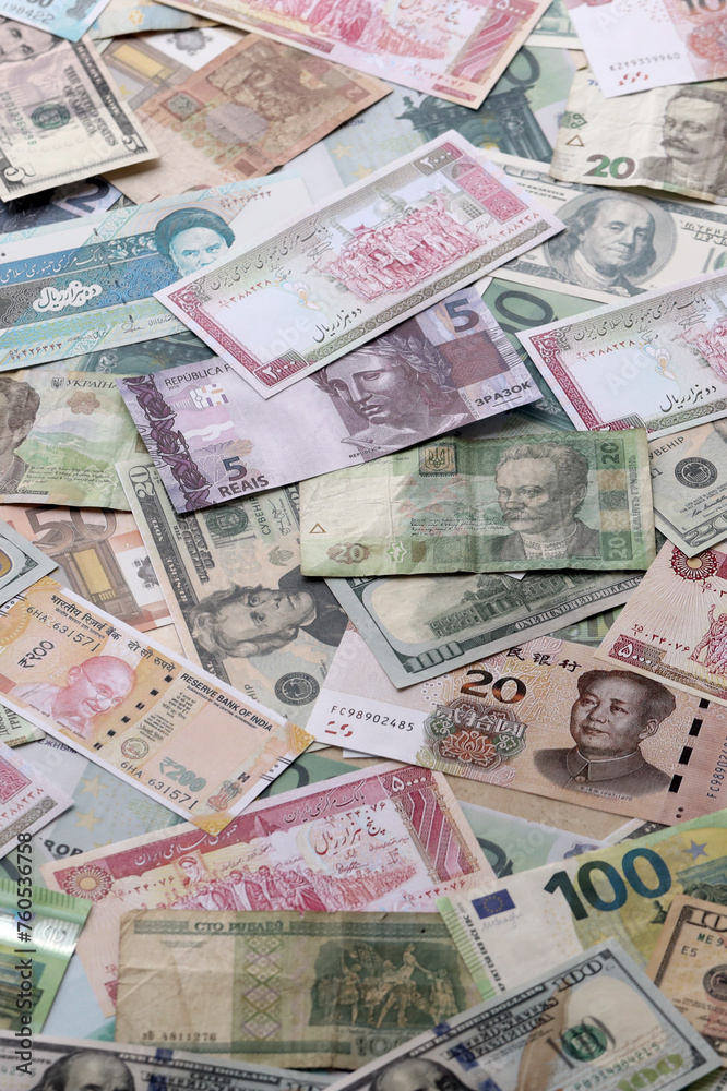 Many banknotes of different currency. Background of big amount of random money bills close up