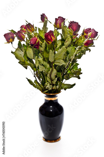 Dried bouquet of red roses in a black vase