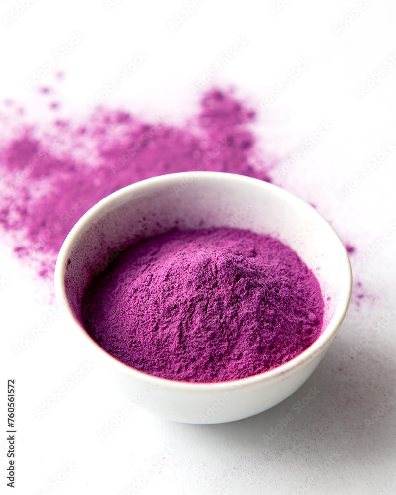 Organic Purple Sweet Potato Powder in a White Ceramic Bowl. Natural Food Coloring Concept Organic Purple Sweet Potato Powder in a White Ceramic Bowl. Natural Food Coloring Concept