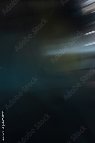 Abstract effect in dark tones, blur in the movement of light from the lights on the old wall at night. Background for design with copy space. Vertical orientation. Copy space