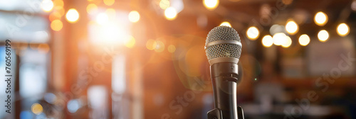 a microphone on stage with a blurred background, representing public speaking or presentation. Web banner with empty space for text photo