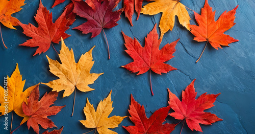 Autumn background with colored red leaves on blue slate background. Top view