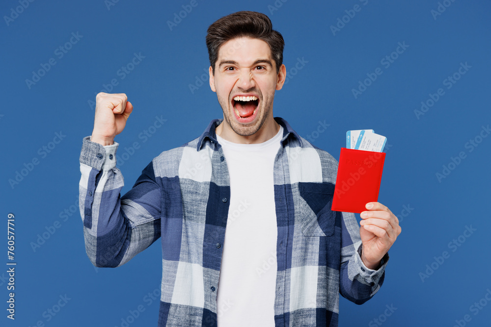 Traveler man wear shirt casual clothes hold passport ticket do winner gesture isolated on plain blue background. Tourist travel abroad in free spare time rest getaway. Air flight trip journey concept. Traveler man wear shirt casual clothes hold passport ticket do winner gesture isolated on plain blue background. Tourist travel abroad in free spare time rest getaway. Air flight trip journey concept.