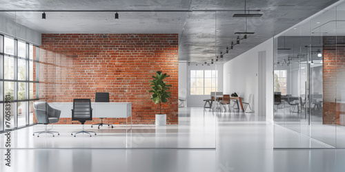 A modern office space with glass walls and white floors, featuring brick wall accents, a desk setup with chairs photo