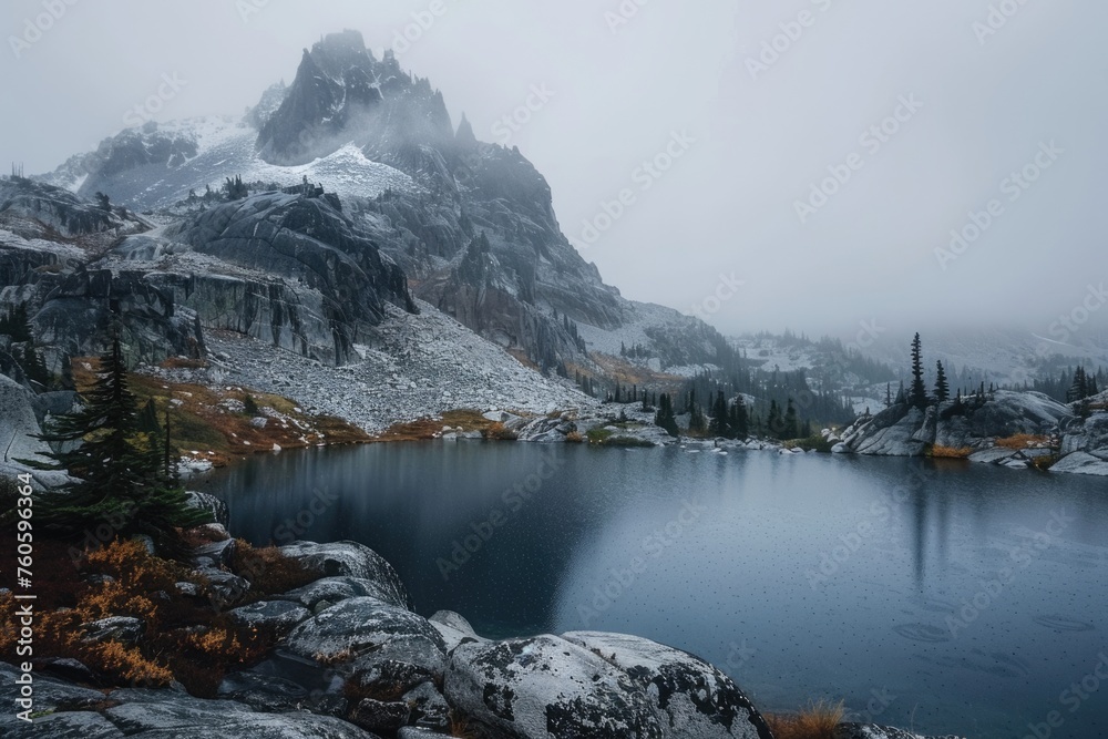 Gray Mountain Lake in Autumn: A Foggy View of Rocky Pinnacle, Snowy Peak, and Misty Landscape Under Gray Overcast Sky in Rainy Weather