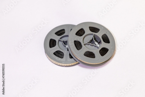 Selective focus, close up on two old school 8mm film reels against a white background. 