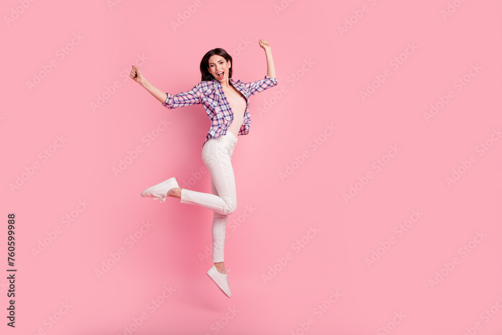 Full length side profile body size photo funny beautiful her she lady jump high holiday fists raised wear shoes casual checkered plaid shirt white jeans denim clothes outfit isolated pink background