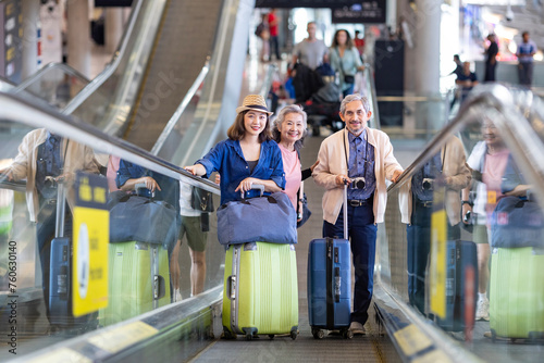 Group of Asian family tourist passenger with senior parent using escalator at the airport terminal for airline travel and holiday vacation