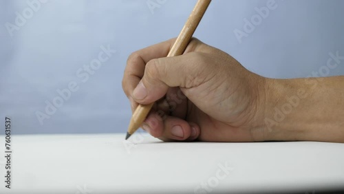 Hand is painted on the table on a sheet of white paper sketchbook.
Hold pencil writing to a blank drawing paper background.
Slow motion.